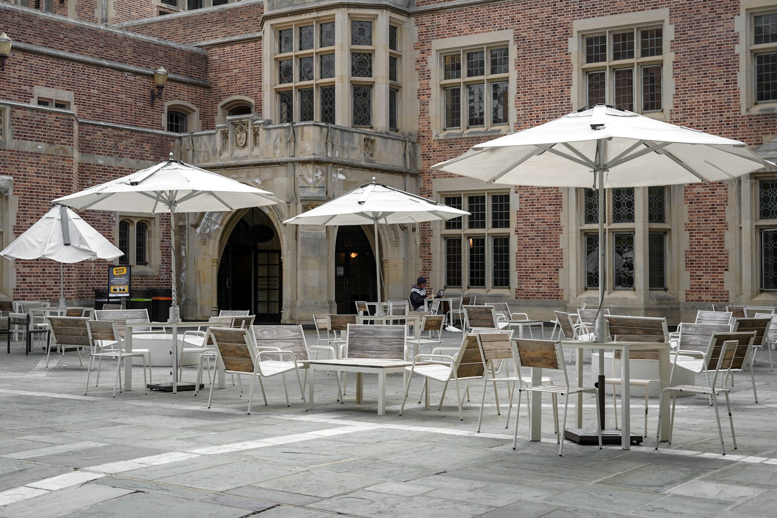 tables and chairs with umbrellas in front of a building